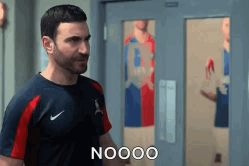 A Man In A Nike Shirt Is Standing In Front Of A Door And Talking To Someone . GIF
