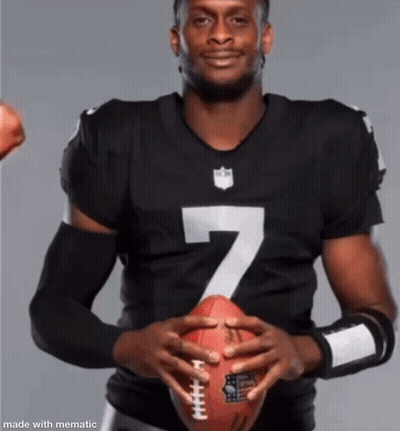 A Man In A Number 7 Jersey Is Holding A Football In His Hands GIF