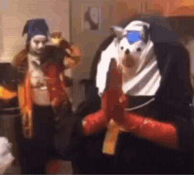 A Man In A Nun Costume Is Holding A Gun Next To A Woman In A Costume . GIF