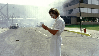 A Man In A Nurse 'S Uniform Is Standing In Front Of An Emergency Entrance GIF