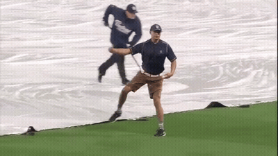 A Man In A Ny Hat Is Standing On A Field With His Arms Outstretched GIF