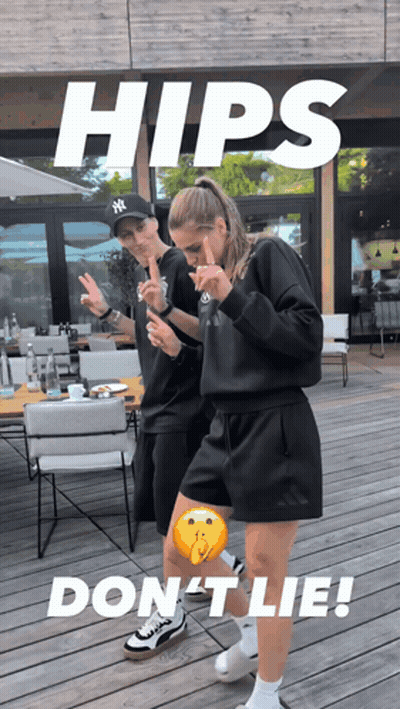 A Man In A Ny Hat Stands Next To A Woman In A Black Outfit GIF