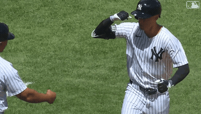 A Man In A Ny Yankees Uniform Is Giving A Fist Bump To Another Man GIF