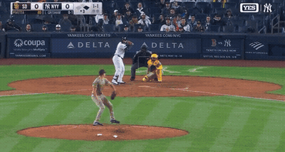 A Man In A Ny Yankees Uniform Is Walking On A Field GIF