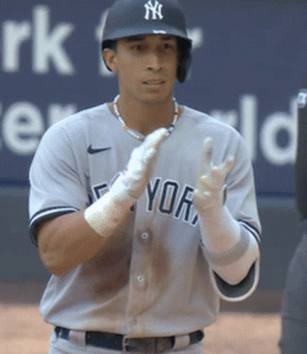 A Man In A Ny Yankees Uniform Stands On The Field GIF