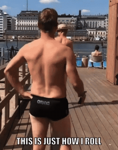 A Man In A Pair Of Arena Swim Trunks Is Standing On A Pier GIF