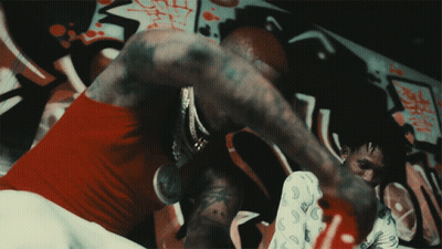 A Man In A Paisley Shirt Is Boxing With Another Man GIF