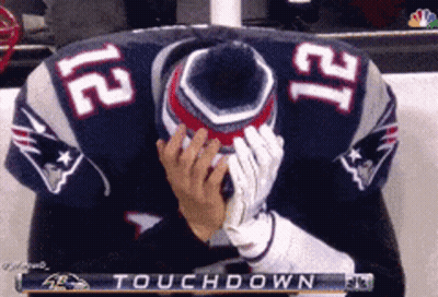 A Man In A Patriots Jersey Is Covering His Face During A Touchdown GIF