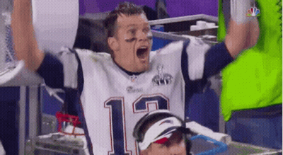 A Man In A Patriots Jersey Is Raising His Hands In The Air . GIF