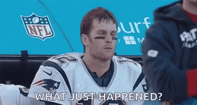 A Man In A Patriots Jersey Is Sitting In A Locker Room And Talking To Someone . GIF