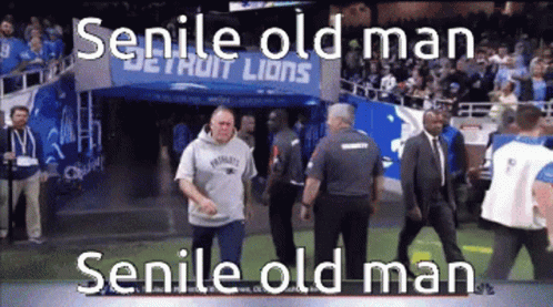 A Man In A Patriots Sweatshirt Walks Across A Football Field GIF