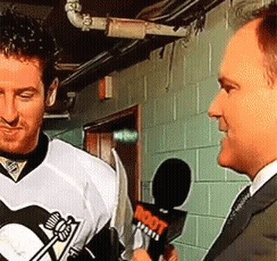 A Man In A Penguins Jersey Is Being Interviewed By Another Man GIF