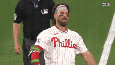 A Man In A Phillies Jersey Stands On A Field GIF
