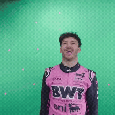 A Man In A Pink And Black Racing Suit Is Laughing And Smiling . GIF