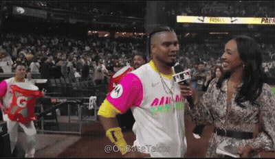 A Man In A Pink And Yellow Jersey Is Being Interviewed By A Female Reporter GIF