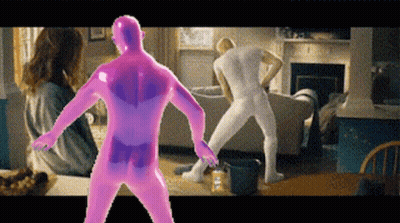 A Man In A Pink Bodysuit Is Dancing In A Living Room With Other People GIF
