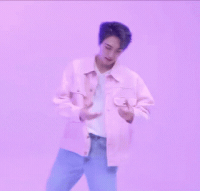 A Man In A Pink Jacket Is Making A Heart With His Hands GIF