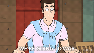A Man In A Pink Shirt And Blue Sweater Says " We 'Re Going To War " GIF