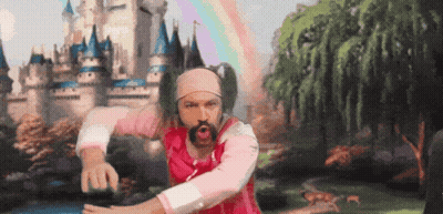 A Man In A Pink Shirt And Headband Is Dancing In Front Of A Castle GIF