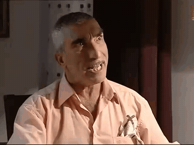 A Man In A Pink Shirt Has A Cross On His Pocket GIF