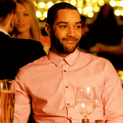A Man In A Pink Shirt Holds A Wine Glass GIF