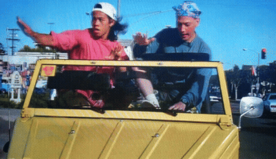 A Man In A Pink Shirt Is Driving A Yellow Car GIF