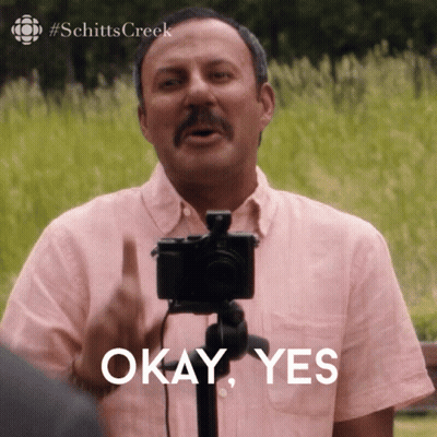 A Man In A Pink Shirt Is Holding A Camera And Says " Okay Yes " GIF