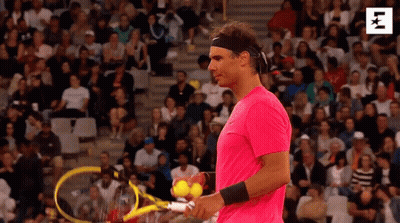 A Man In A Pink Shirt Is Holding A Tennis Racket And Balls . GIF