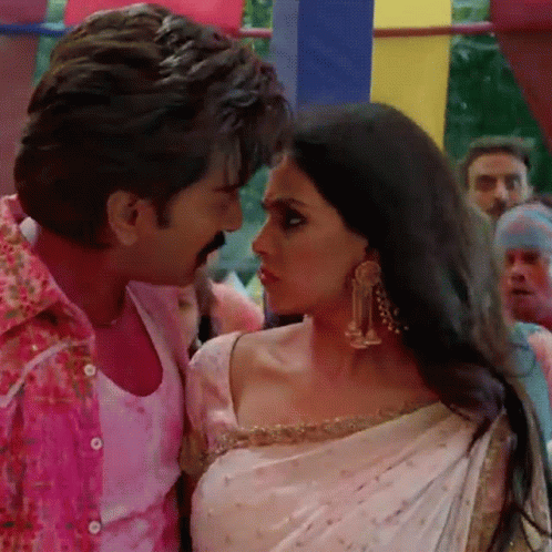 A Man In A Pink Shirt Is Kissing A Woman In A White Sari GIF