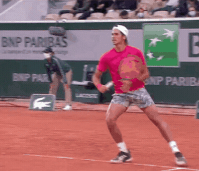 A Man In A Pink Shirt Is Playing Tennis In Front Of A Bnp Paribas Banner GIF