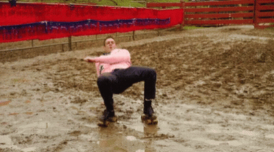 A Man In A Pink Shirt Is Sitting In A Muddy Field GIF