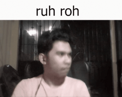 A Man In A Pink Shirt Is Sitting In Front Of A Screen That Says Ruh Roh GIF