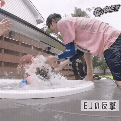 A Man In A Pink Shirt Is Splashing Another Man In A Bathtub With The Words Go One Written Above Him GIF