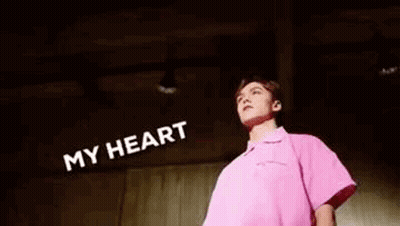 A Man In A Pink Shirt Is Standing In Front Of A Wall With Foam Coming Out Of His Mouth And Head . GIF