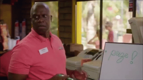 A Man In A Pink Shirt Is Standing In Front Of A White Board That Says Page GIF
