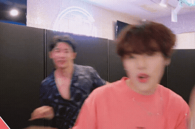 A Man In A Pink Shirt Is Standing Next To Another Man In A Black Shirt GIF