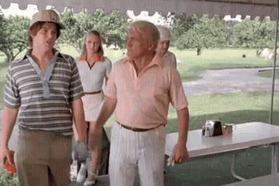 A Man In A Pink Shirt Is Standing Next To Another Man In A Striped Shirt . GIF