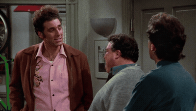 A Man In A Pink Shirt Is Talking To Two Other Men In A Room GIF