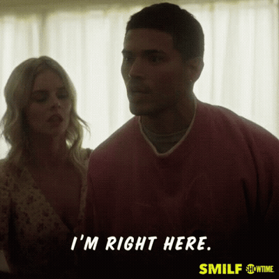 A Man In A Pink Shirt Says " I 'M Right Here " While Standing Next To A Woman GIF