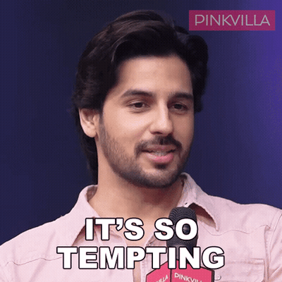 A Man In A Pink Shirt Says It 'S So Tempting In Front Of A Microphone GIF