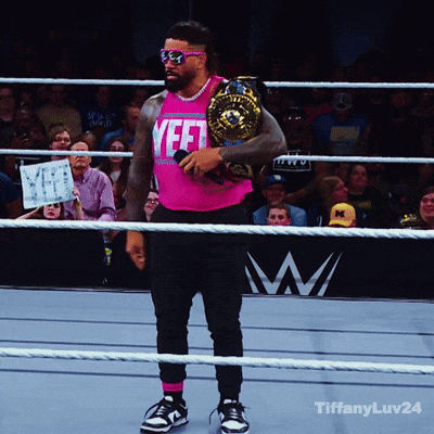 A Man In A Pink Shirt That Says Yeet Holds A Championship Belt GIF