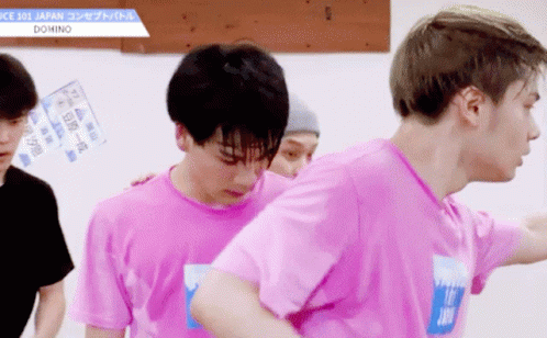 A Man In A Pink Shirt With The Word Domino On His Chest GIF