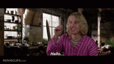 A Man In A Pink Striped Shirt Is Saying Hello .. GIF