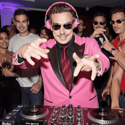 A Man In A Pink Suit And Headphones Is Playing Music On A Dj Mixer GIF