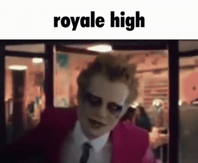 A Man In A Pink Suit And Tie Is Standing In Front Of A Window With The Words `` Royale High '' Written On It . GIF