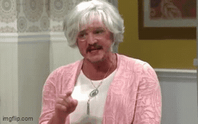 A Man In A Pink Sweater And Wig Is Holding A Piece Of Paper In His Hand . GIF