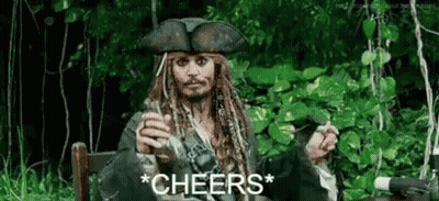 A Man In A Pirate Costume Is Sitting In A Chair Holding A Glass Of Wine And A Cigarette . GIF