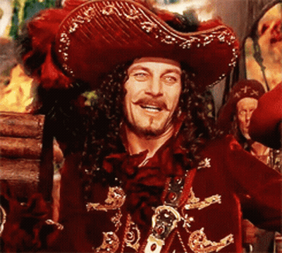 A Man In A Pirate Costume Is Smiling And Holding A Sword GIF