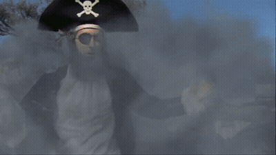 A Man In A Pirate Costume Is Standing In Front Of A Sign For Nickelodeon GIF