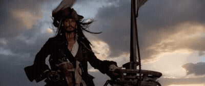A Man In A Pirate Costume Is Standing On Top Of A Ship . GIF